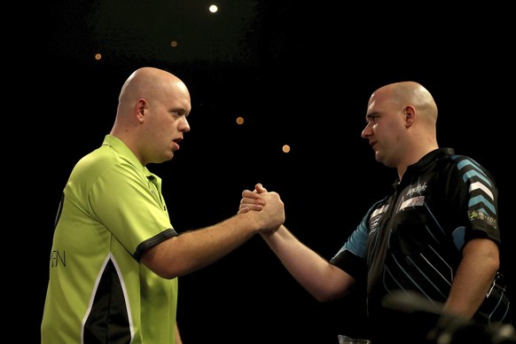 England&#039;s Rob Cross greets his opponent Michael van Gerwen at the start of their semifinal match of the World Darts Championship at Alexandra Palace, London, Saturday Dec. 30, 2017. (Steven Pasto ...