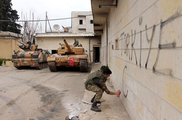 A Turkish soldier writes &quot;Turkey&quot; on a wall, near to tanks in position, in the city center of Afrin, northwestern Syria, Sunday, March 18, 2018. Turkey&#039;s president said Sunday the Turki ...