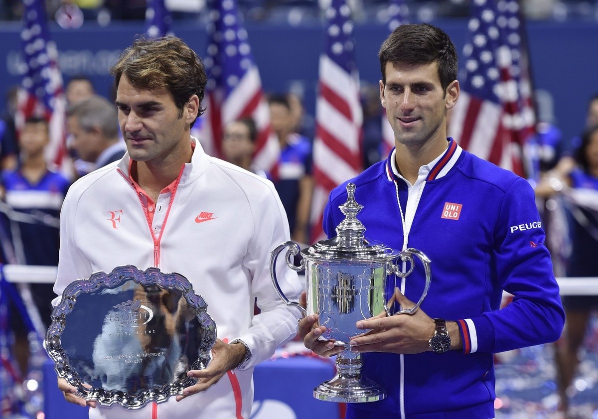 epa04929478 Novak Djokovic of Serbia (R) holds up the championship trophy after defeating Roger Federer of Switzerland (L) to win the men's final on the fourteenth day of the 2015 US Open Tennis  ...