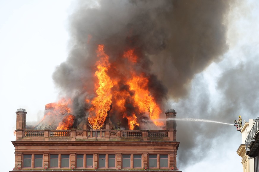 A firefighter trains a hose on a major blaze which has broken out at the Primark store in Belfast city centre, in Northern Ireland, Tuesday Aug. 28, 2018. The Northern Ireland Fire and Rescue Service  ...