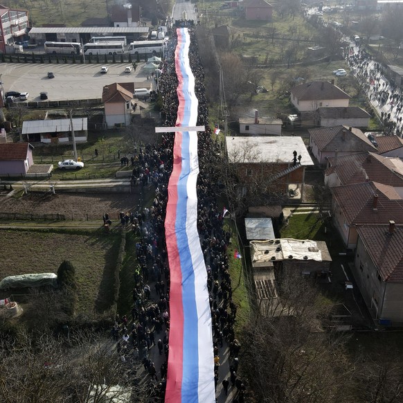 Kosovo Serbs carry a giant Serbian flag during a protest near a barricade on the road near the village of Rudare, north of Serb-dominated part of ethnically divided town of Mitrovica, Kosovo, Thursday ...