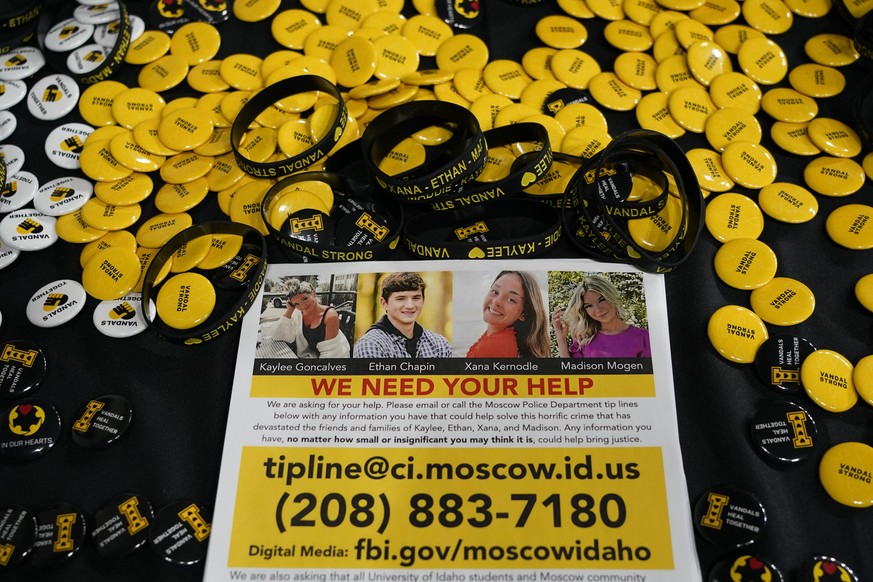 FILE - A flyer seeking information about the killings of four University of Idaho students who were found dead is displayed on a table along with buttons and bracelets on Nov. 30, 2022, during a vigil ...