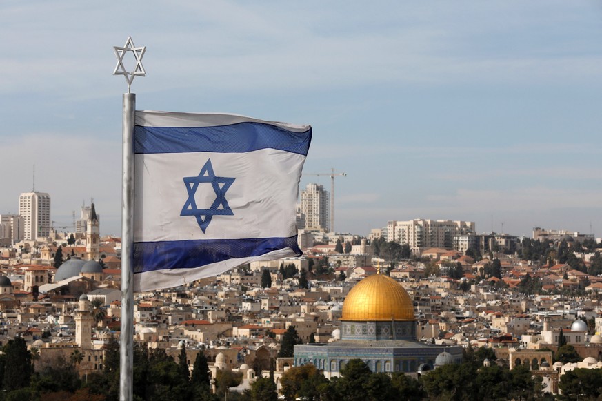 epaselect epa06368385 Israeli flag flies near the ancient Jewish cemetery on the Mount of Olives overlooking the old city of Jerusalem, 05 December 2017. Speculation in the media have suggested that U ...