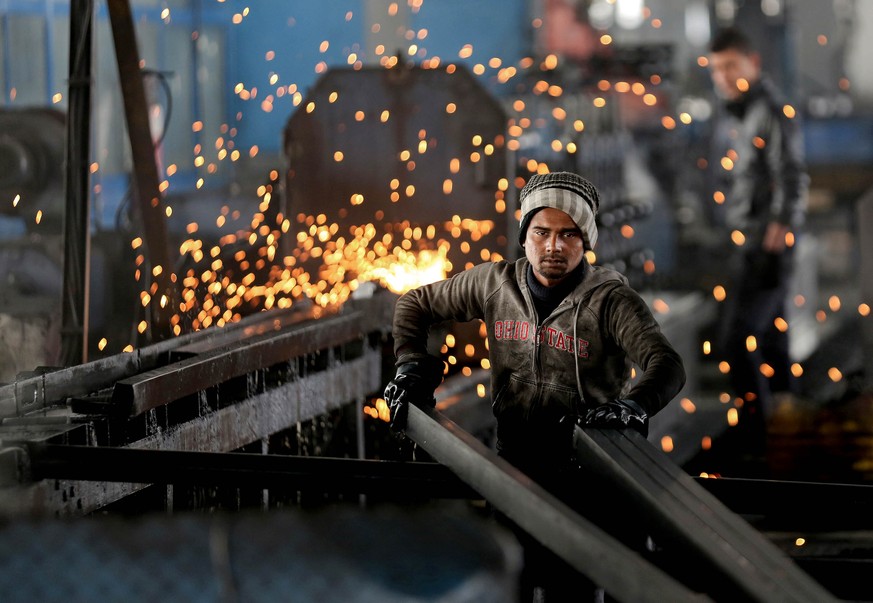 In this Thursday, Feb. 25, 2016 photo, a worker from India arranges steel tubes at a factory in the Muwaqer Industrial Estate, in northern Jordan. A new trade deal with Europe, a rush of foreign inves ...