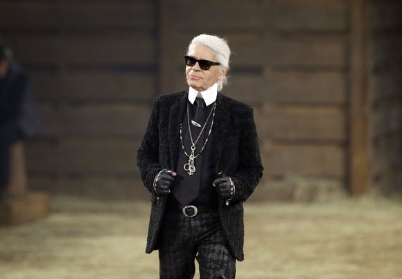 FILE - In this Tuesday, Dec. 10, 2013 file photo, Chanel designer Karl Lagerfeld takes a bow at the end of his Metiers d&#039;Art fashion show, Tuesday, Dec. 10, 2013, in Dallas. Chanel&#039;s iconic  ...