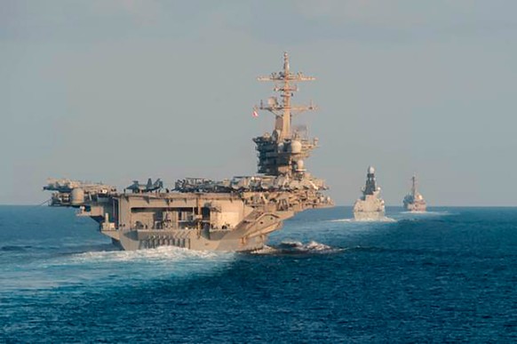 FILE - In this Nov. 19, 2019, photo made available by U.S. Navy, the aircraft carrier USS Abraham Lincoln, left, the air-defense destroyer HMS Defender and the guided-missile destroyer USS Farragut tr ...