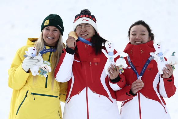 From left, silver medalist Australia's Danielle Scott (7), gold medalist China's Mengtao Xu (1), and bronze medalist China's Qi Shao (9) celebrate after the women's freestyle skiin ...