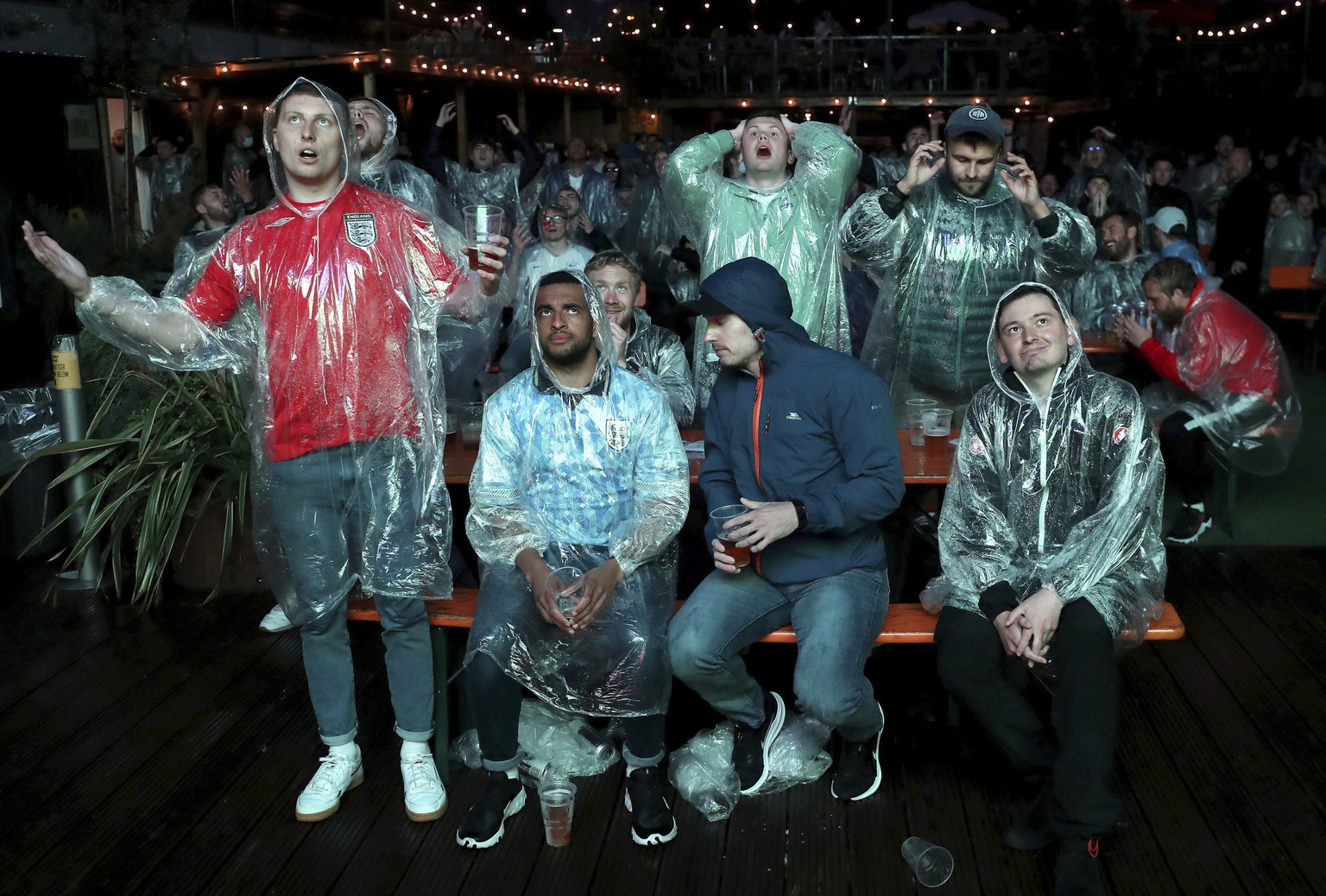 Fans react as they watch the the Euro 2020 soccer championship group D match between England and Scotland, at Wembley stadium, from Vinegar Yard, in London, England, Friday, June 18, 2021. Kieran Clee ...