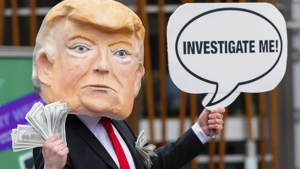 IMAGE DISTRIBUTED FOR AVAAZ - A member of the global citizens movement Avaaz wearing a mask of former US President Donald Trump holds a sign reading "Investigate me", outside the Scottish Pa ...
