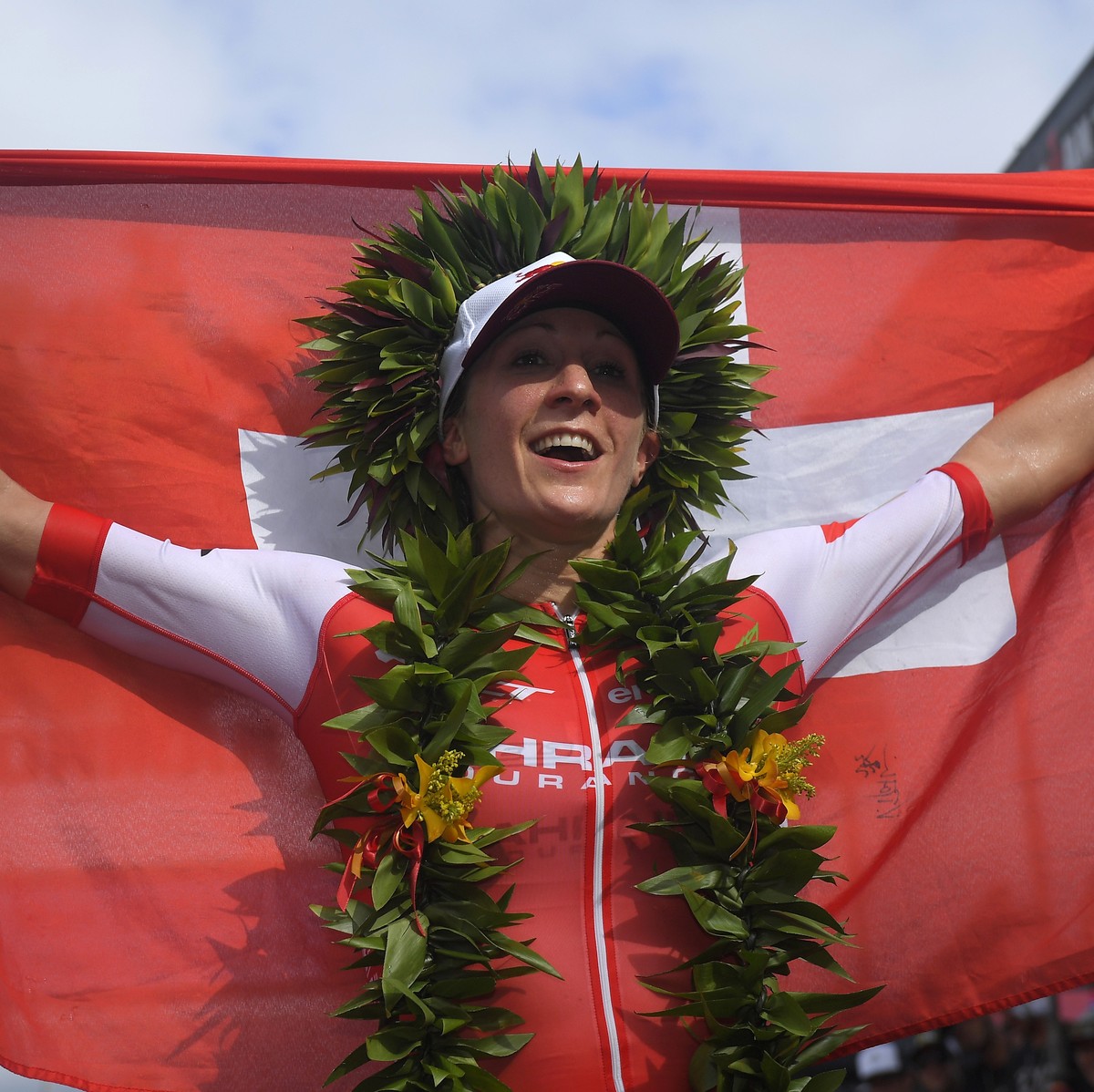 Daniela Ryf, of Switzerland, holds up her country's flag after winning the women's group of the Ironman World Championship Triathlon, Saturday, Oct. 8, 2016, in Kailua-Kona, Hawaii. (AP Phot ...