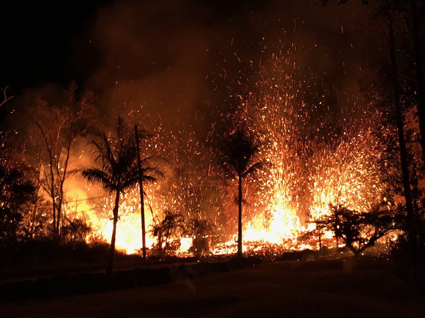 epa06715782 A handout photo made available by the United States Geological Survey shows a new fissure erupting from Luana Street, Leilani Estates subdivision on Kilauea Volcano&#039;s lower East Rift  ...