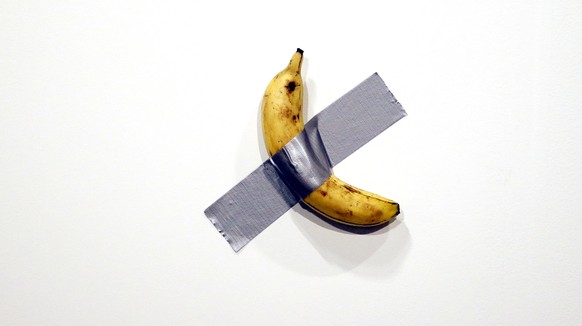 epaselect epa08047501 Italian artist Maurizio Cattelan&#039;s piece &#039;Comedian&#039; (a banana duct taped to the wall) is shown during Art Basel in Miami, Florida, USA, 05 December 2019. Art Basel ...