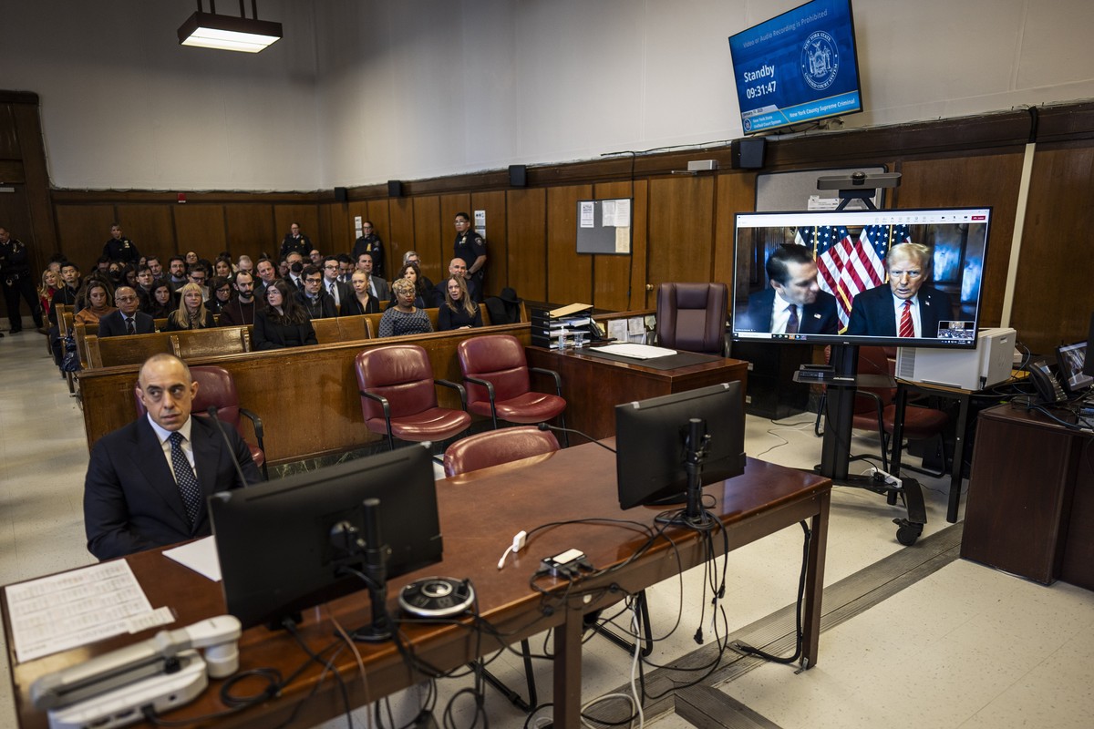 Attorney Emil Bove, left, listens as attorney Todd Blanche and President-elect Donald Trump, seen on a television screen, appear virtually for sentencing for Trump's hush money conviction in a Ma ...