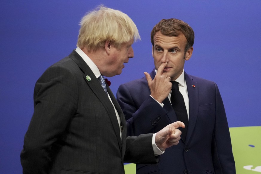 British Prime Minister Boris Johnson, left, talks with French President Emmanuel Macron, at the COP26 U.N. Climate Summit in Glasgow, Scotland, Monday, Nov. 1, 2021. The U.N. climate summit in Glasgow ...