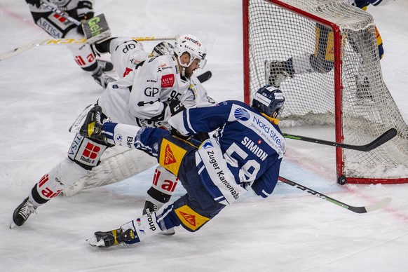 Dario Simion, rechts, von Zug im Spiel gegen Thomas Wellinger, links, von Lugano beim Eishockey Meisterschaftsspiel in der Qualifikation der National League zwischen dem EV Zug und dem HC Lugano vom M ...