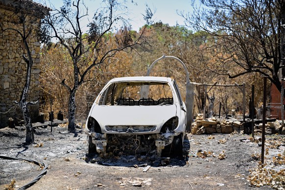 A burned car sits in the drive of a house after a wildfire in Cotignac, France, Thursday, Aug. 6, 2026, as drought conditions worsen following a heatwave and water shortages across much of France. (AP ...