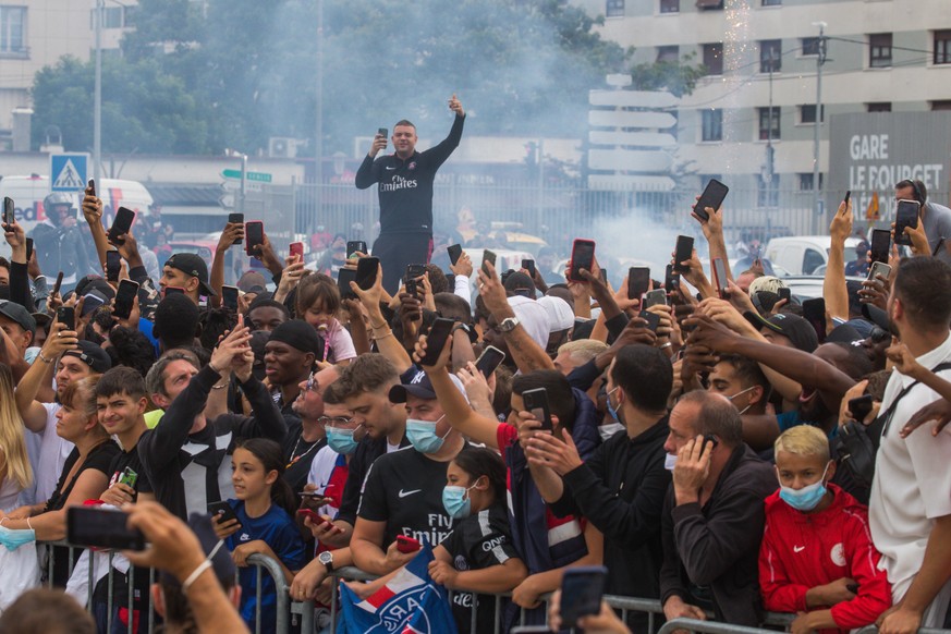 epa09408345 PSG fans gather outside the &#039;Le Bourget&#039; airport, near Paris, 09 August 2021, where Argentinian striker Lionel Messi arrived to sign a contract with French soccer club Paris Sain ...