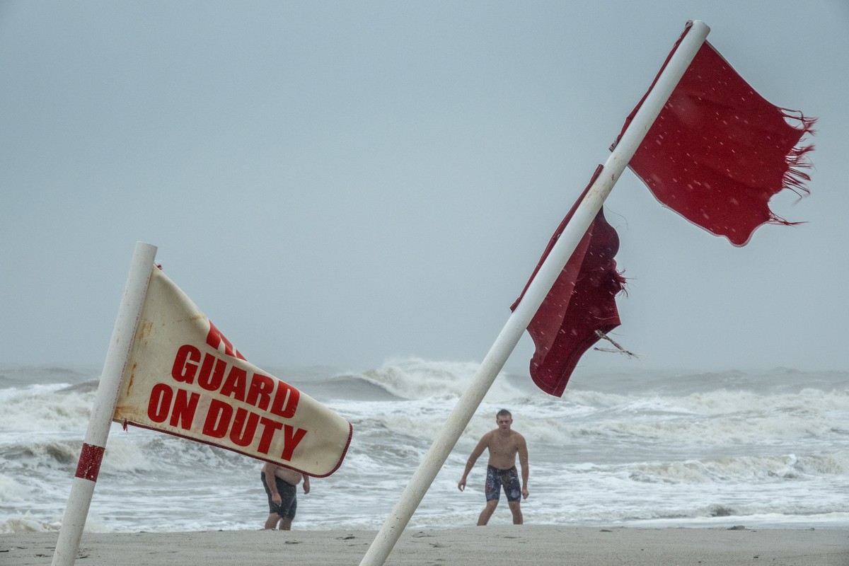 epaselect epa11534159 Red flags are seen as people walk on the beach during the rain from tropical storm Debby in in Myrtle Beach, South Carolina, USA, 07 August 2024. According to the National Hurric ...