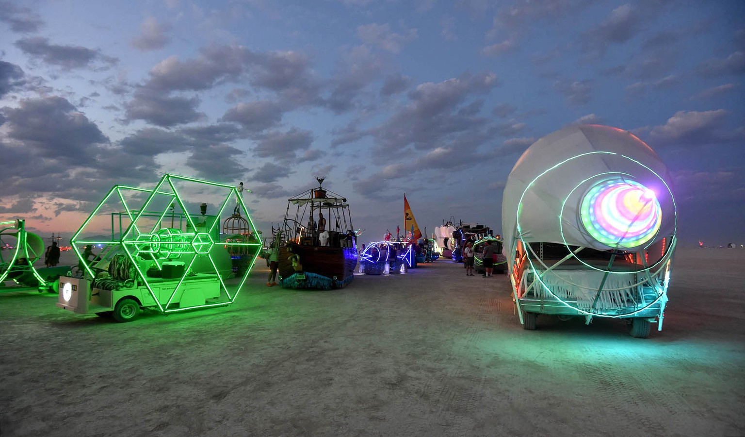 In this Sunday night, Aug. 23, 2014 photo, art cars are lined up to be registered at the Black Rock DMV during the annual Burning Man event on the Black Rock Desert of Gerlach, Nev. (AP Photo/Reno Gaz ...