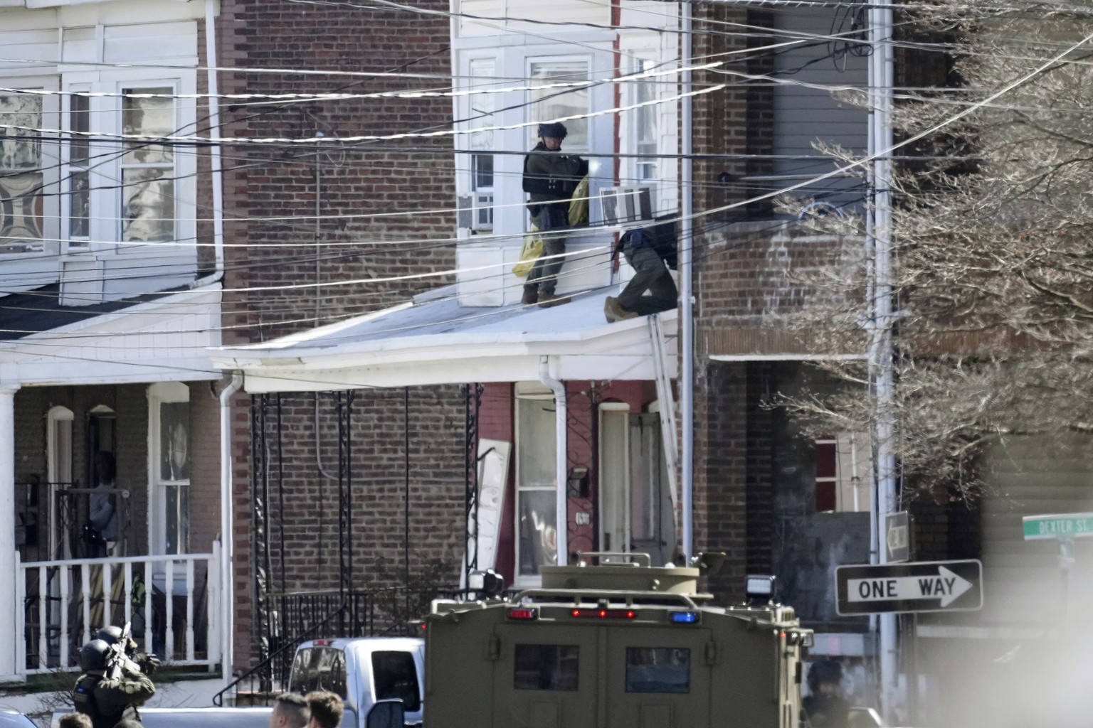 Police surround a home in Trenton, N.J., Saturday, March 16, 2024. A suspect has barricaded himself in the home and was holding hostages after shooting three people to death in suburban Philadelphia.  ...