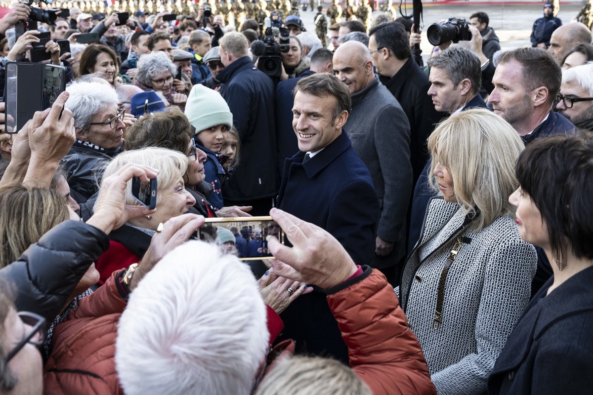 Switzerland President Alain Berset, center, his wife Muriel Zeender Berset, right, and French President Emmanuel Macron, center left, and his wife Brigitte Macron, center right, greet people in front  ...