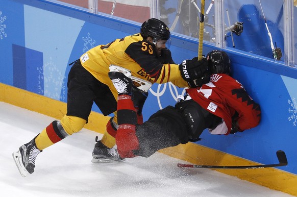 Felix Schutz (55), of Germany, slams Maxim Noreau (56), of Canada, into the wall during the first period of the semifinal round of the men's hockey game at the 2018 Winter Olympics in Gangneung, South Korea, Friday, Feb. 23, 2018. (AP Photo/Patrick Semansky)