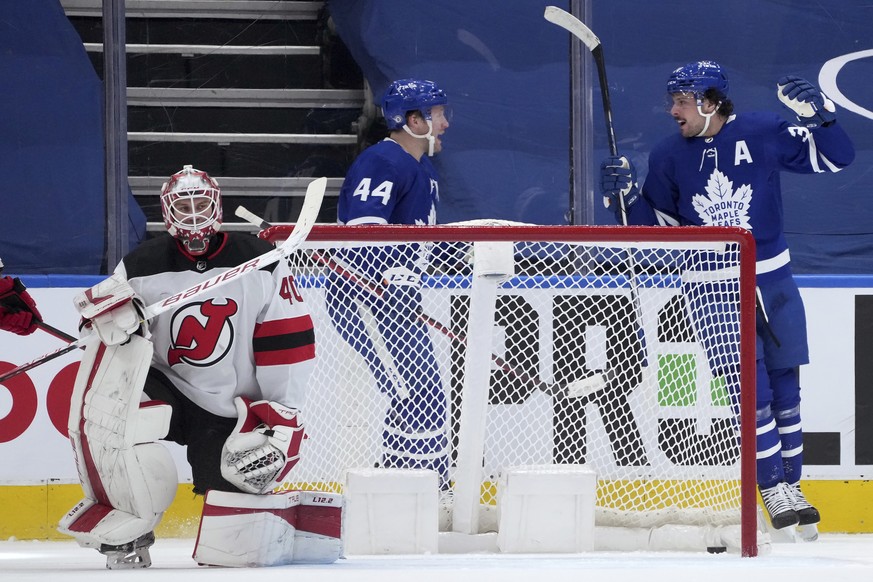 Toronto Maple Leafs forward Auston Matthews (34) celebrates his goal on New Jersey Devils goaltender Akira Schmid (40) with teammate Morgan Rielly (44) during the first period of an NHL hockey game Mo ...