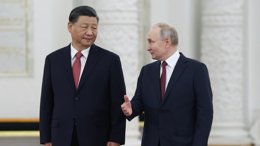 FILE - Russian President Vladimir Putin, right, speaks to Chinese President Xi Jinping as they attend an official welcome ceremony at The Grand Kremlin Palace, in Moscow, Russia, March 21, 2023. Chine ...