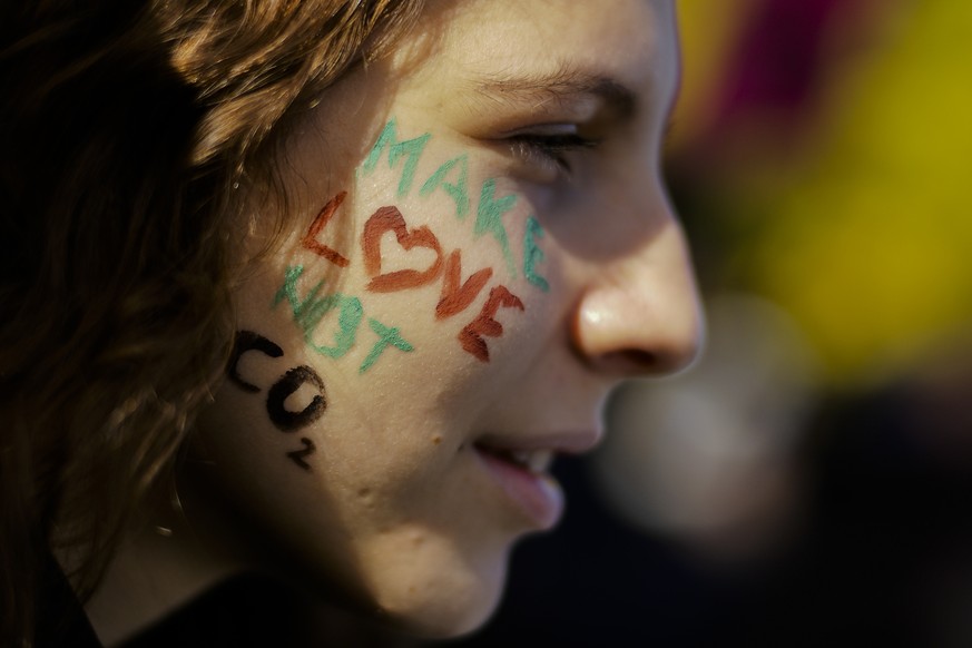 A student painted her face with a slogan attends a protest of the Fridays for Future movement in Berlin, Friday, Oct. 18, 2019. (AP Photo/Markus Schreiber)