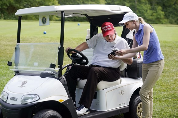 Former President Donald Trump gets an update on his mobile phone during the pro-am round of the Bedminster Invitational LIV Golf tournament in Bedminster, NJ., Thursday, July 28, 2022. (AP Photo/Seth  ...