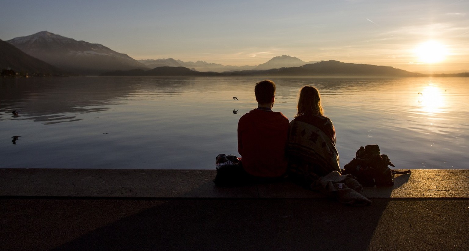 Jugendliche geniessen die schoene Abendstimmung am Zugersee am Freitag, 5. Februar 2016, in Zug. (KEYSTONE/Alexandra Wey)