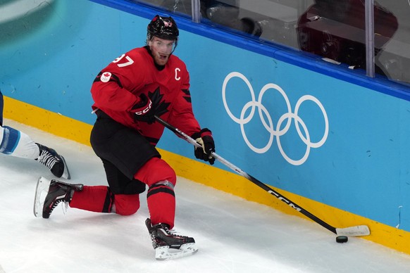 Canada's Connor McDavid handles the puck behind the net during the second period of a men's ice hockey semifinal game against Finland at the 2026 Winter Olympics in Milan, Italy, Friday, Feb ...