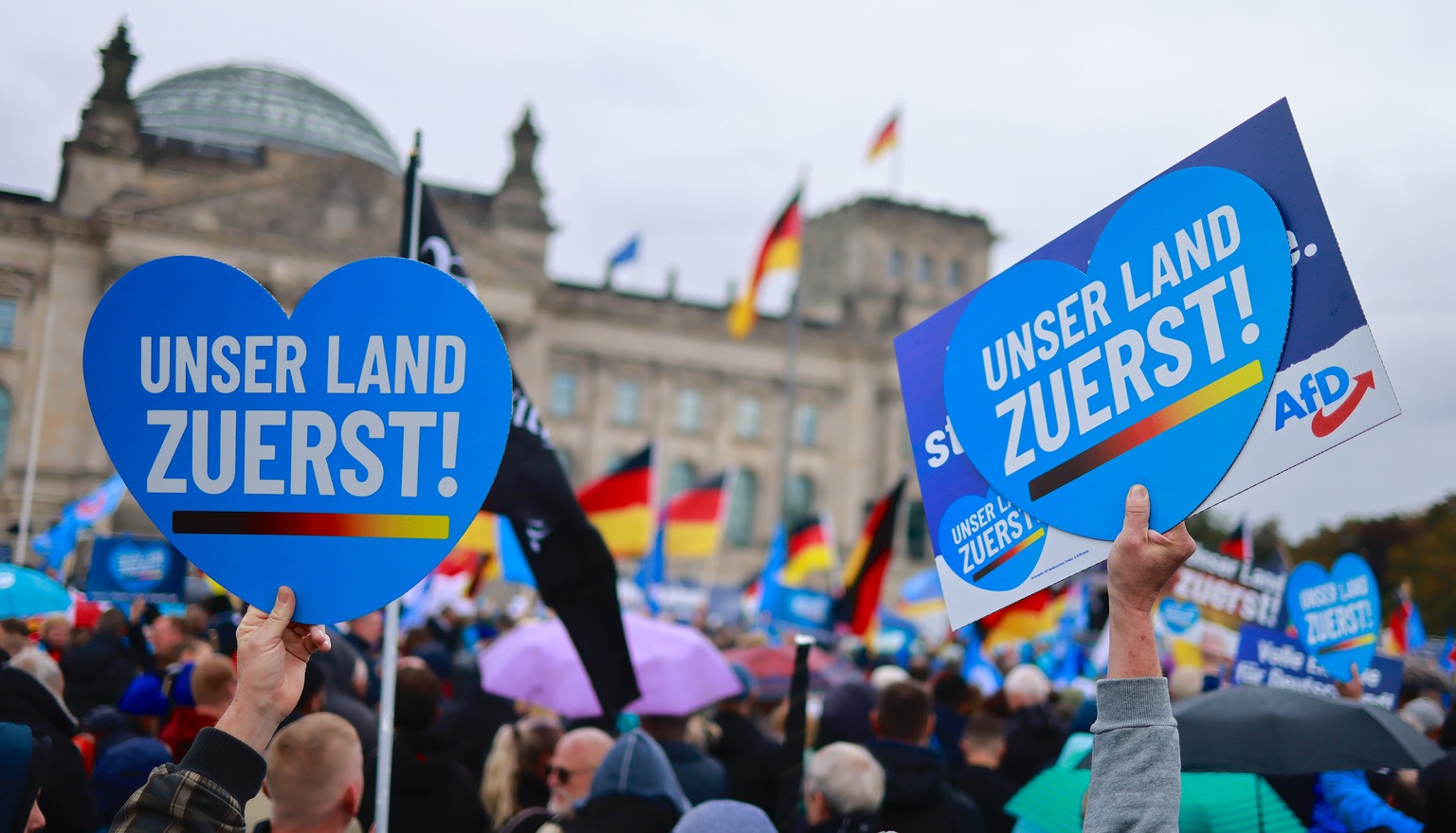 epa10230592 Protesters hold placards reading &#039;Our country first!&#039; as they demonstrate in front of Reichstags building in Berlin, Germany, 08 October 2022. The right-wing populist Alternative ...