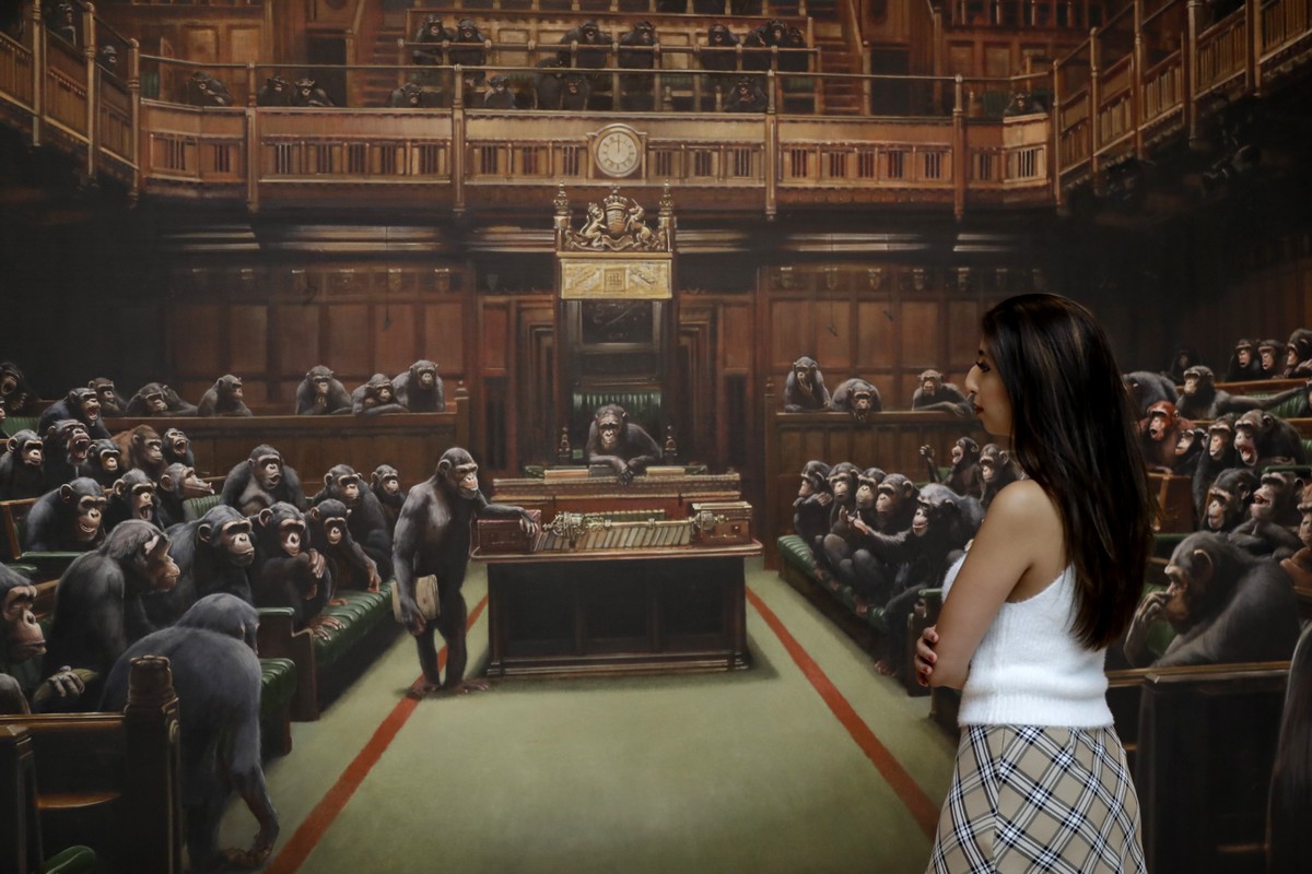 A Sotheby's employee looks at a painting by anonymous street artist Banksy on display at Sotheby's auction rooms in London, Friday, Sept. 27, 2019. The painting will be offered for sale on O ...