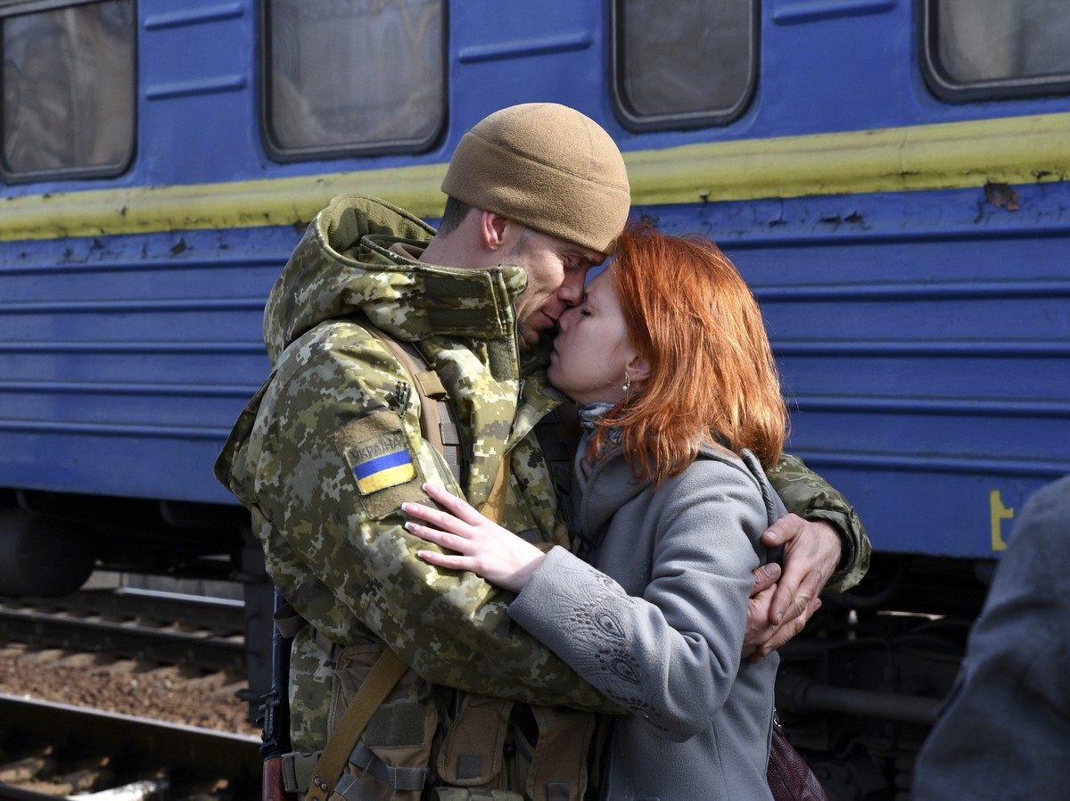 A couple embrace prior to the woman boarding a train carriage leaving for western Ukraine, at the railway station in Kramatorsk, eastern Ukraine, Sunday, Feb. 27, 2022. The U.N. refugee agency says ne ...