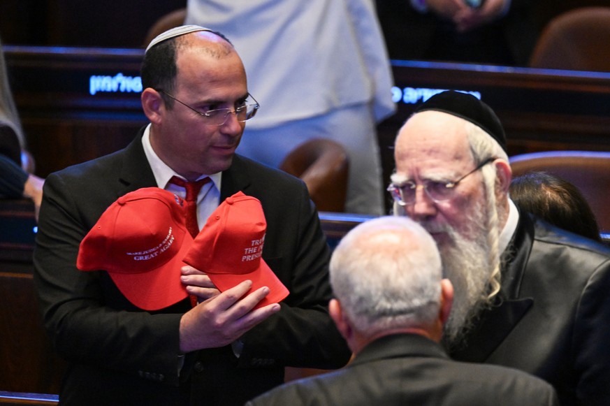 People wearing hats that read &quot;Trump The Peace President&quot; inside the Knesset as President Donald Trump prepares to deliver remarks, Monday, Oct. 13, 2025, in Jerusalem. (Kenny Holston/The Ne ...