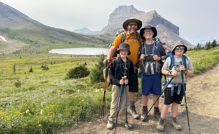 This undated photo shows the Campbell family, wearing sun protection shirts and hats, posing for a photo during a hike in the Rocky Mountains near their Calgary, Alberta home, (Lynn Campbell via AP)
H ...