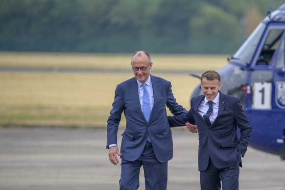 epa13117242 German Chancellor Friedrich Merz and French President Emmanuel Macron arrive at Noervenich Airbase for defence consultations between the German and French governments as part of the 26th G ...
