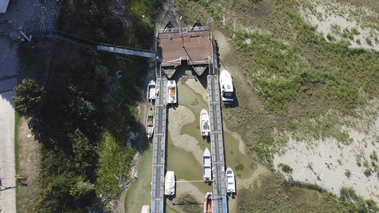 Boats lie on the dried riverbed at a tourist dock along the Po river in Sermide, Italy, Thursday, Aug. 11, 2022. The river Po runs 652 kilometers (405 miles) from the northwestern city of Turin to Ven ...