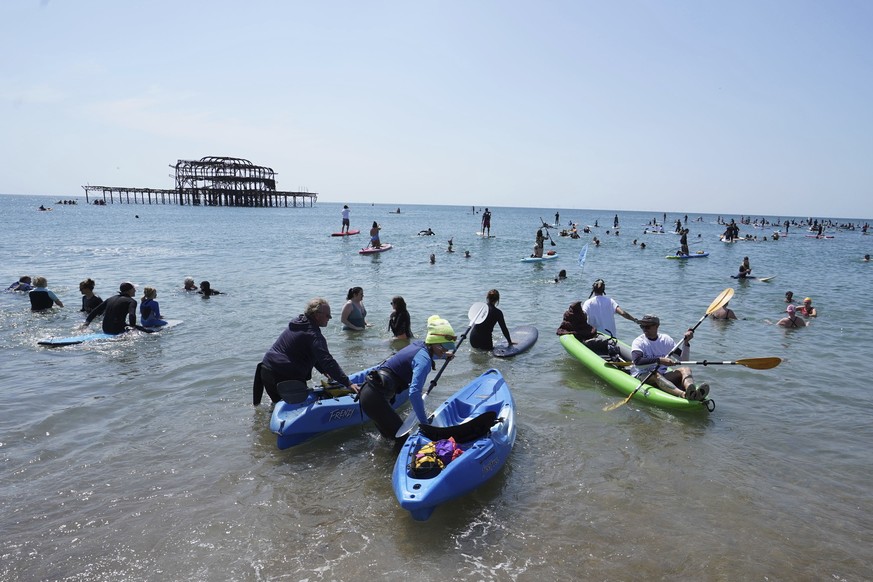 Protesters take to the water as Surfers Against Sewage hold a UK-wide paddle-out protest at Brighton West Pier in East Sussex, England, Saturday May 20, 2023, demanding an end to sewage discharges int ...