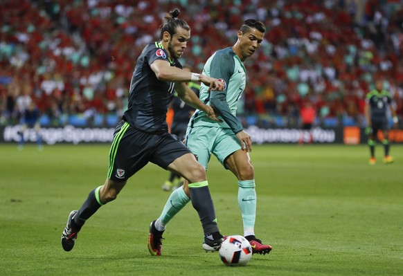 Wales&#039; Gareth Bale, left, and Portugal&#039;s Cristiano Ronaldo compete for the ball during the Euro 2016 semifinal soccer match between Portugal and Wales, at the Grand Stade in Decines-Charpieu ...