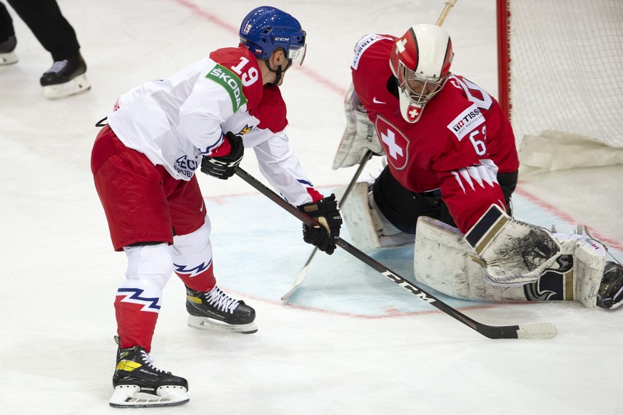 Switzerland&#039;s goaltender Leonardo Genoni, right, blocks the puck past Czech Republic&#039;s forward Jakub Flek, left, during the IIHF 2021 World Championship preliminary round game between Czech  ...