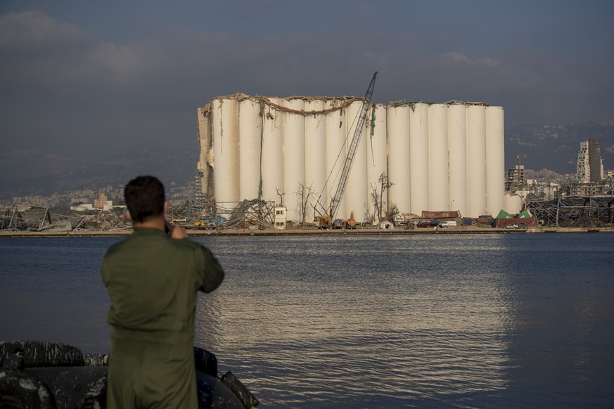 A Brazilian soldier takes a picture of a damaged silo that stands amid rubble and debris at the site of the Aug. 4 explosion that killed more than 170 people, injured thousands and caused widespread d ...