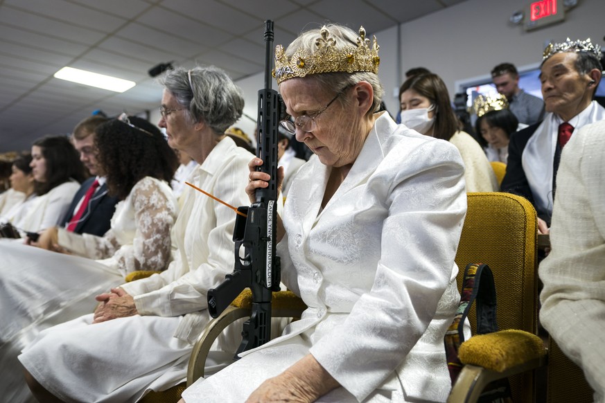 epaselect epa06570828 A parishioner with the Sanctuary Church holds onto her AR-15, which churchgoers were encouraged to bring to a blessing ceremony to rededicate their marriages at the World Peace a ...