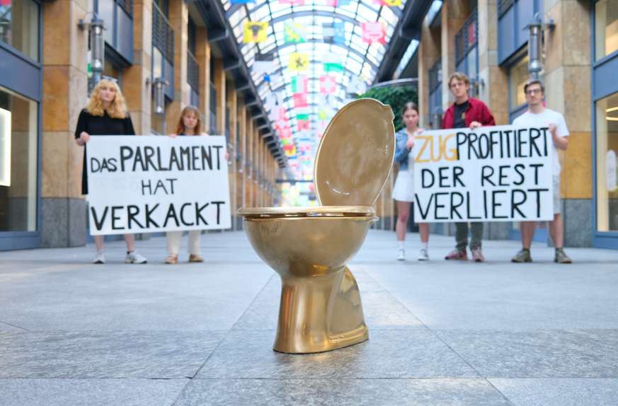 Juso Aktion mit vergoldetem WC zur Verteilung der OECD-Mehreinnahmen. 8. Juni 2023 in Zug.