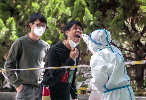 epa09927804 A man takes coronavirus test on the street amid the ongoing Covid-19 lockdown in Shanghai, China, 05 May 2022. Shanghai city reported 13 COVID-19 deaths, 261 locally transmitted cases, and ...
