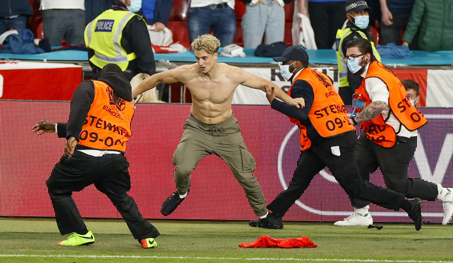 Security tussle with a pitch invader during the Euro 2020 soccer championship final between England and Italy at Wembley stadium in London, Sunday, July 11, 2021. (John Sibley/Pool Photo via AP)