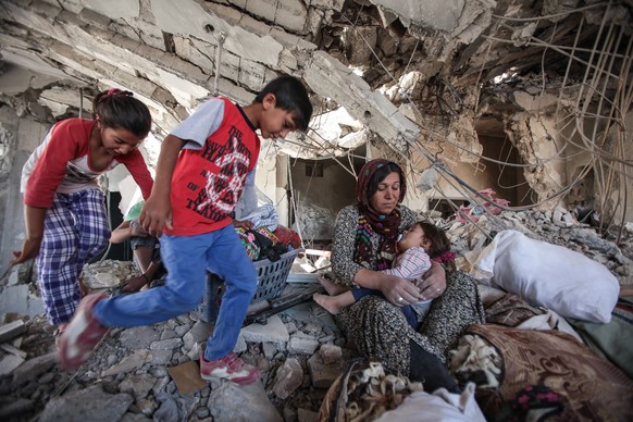 Eine kurdische Familie kehrt in ihr zerstörtes Haus in Kobane zurück.&nbsp;