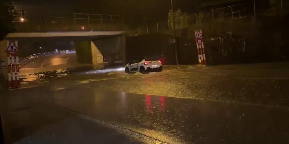 Autos, die in Bern durch riesige Wasserpfützen fahren müssen. Ist die Kanalisation bei Starkregen überfordert?