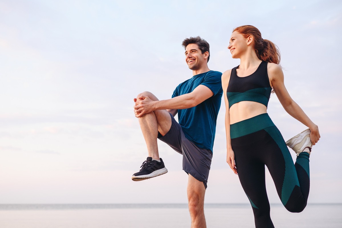 Unteres Paar junge zwei Freunde starke sportliche Sportlerin Sportlerin Mann in Sportkleidung Warmup Training Sport Sport Sport Sport Sport Sport Sport Sport-Sport-Outdoor-Jogg am Meer im Sommer Morge ...